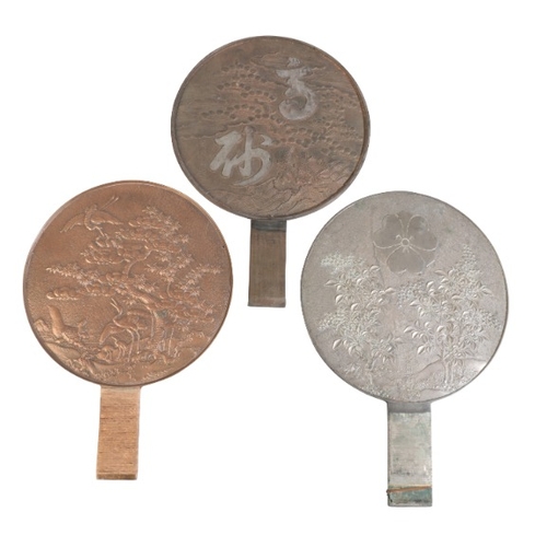 218 - THREE JAPANESE BRONZE KAGAMI OR HAND MIRRORS

Taisho period, early 20th Century, all decorated in re... 