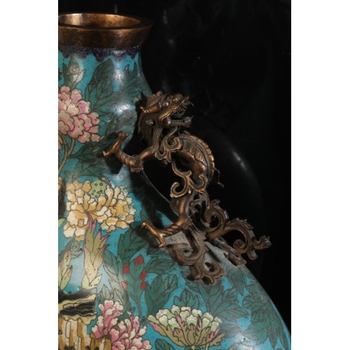 24 - A CHINESE CLOISONNE MOON FLASK

Qing, decorated with peonies against a blue ground, with bronze hand... 