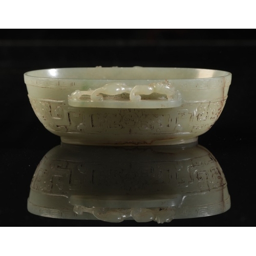 32 - A CHINESE CELADON JADE OVAL BOWL

with a chilong climbing along the projecting side handles, the bod... 