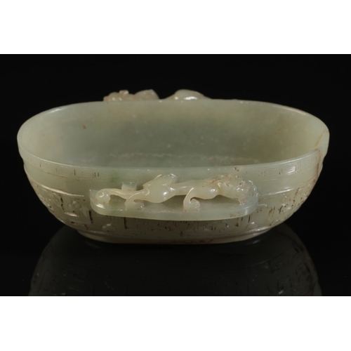 32 - A CHINESE CELADON JADE OVAL BOWL

with a chilong climbing along the projecting side handles, the bod... 