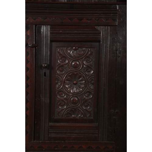 240 - A PANELLED OAK COURT CUPBOARD

17th century and later, with scroll carved frieze and inlaid with par... 