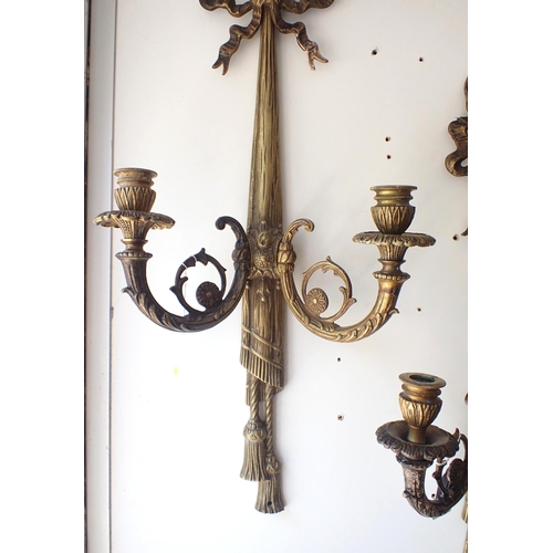 119 - A PAIR OF NEOCLASSICAL STYLE CAST BRASS CANDLE APPLIQUES of tied ribbon design, twin scrolling branc... 