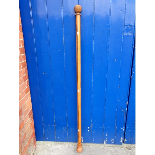 140 - A WOODEN CURTAIN POLE 175 cms long, with wooden curtain rings