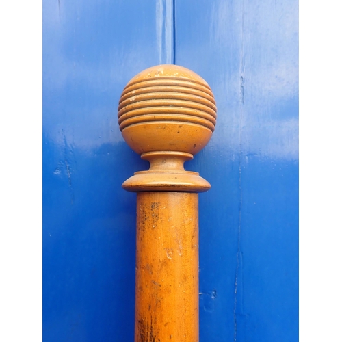 140 - A WOODEN CURTAIN POLE 175 cms long, with wooden curtain rings