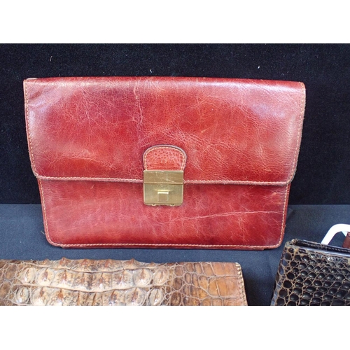 142 - A TAN LEATHER COMPARTMENTED CLUTCH BAG with another crocodie skin clutch bag, a leather sunglasses h... 