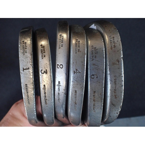 156 - AN OLD GOLF BAG WITH SEVEN VINTAGE IRONS