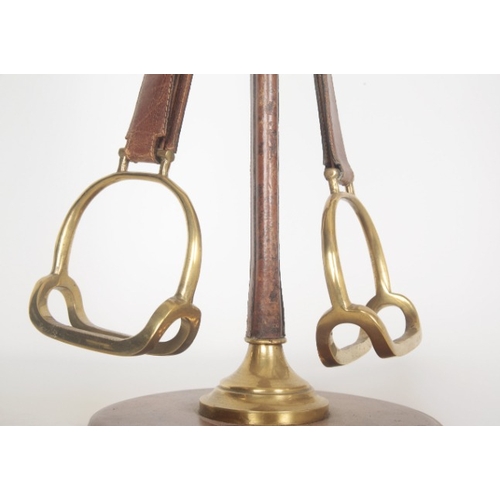 153 - A HERMÃS STYLE STIRRUP LAMP

of leather and brass construction terminating on circular base, 68.5cm... 