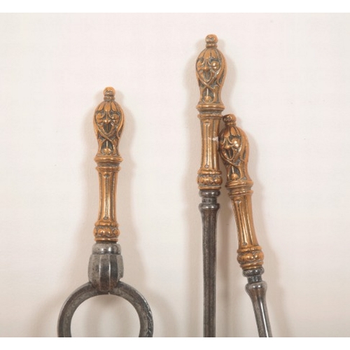 188 - A SET OF ARTS AND CRAFTS FIREPLACE UTENSILS

early 20th century, brass and steel with stylised leaf ... 