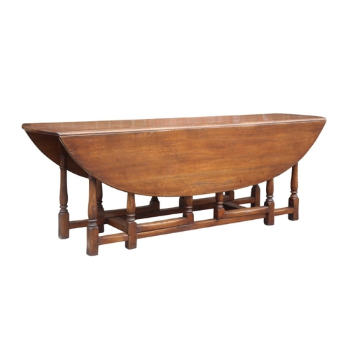 296 - AN ELM WAKE TABLE

of 18th century style, the oval top with twin drop leaves, baluster turned gatele... 