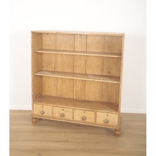 316 - AN OPEN PITCH PINE BOOKCASE

late 19th century, four small drawers with knobs and terminating on bul... 