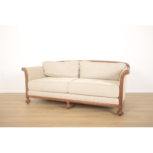 325 - A 1920'S MAHOGANY SETTEE

carved throughout with overlapping laurel leaves, upholstered in stone che... 