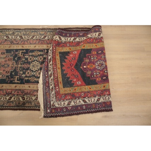 343 - AN ANTIQUE QASHGAI RUNNER

woven in tan, madder and blue with seven medallions and filler motifs on ... 