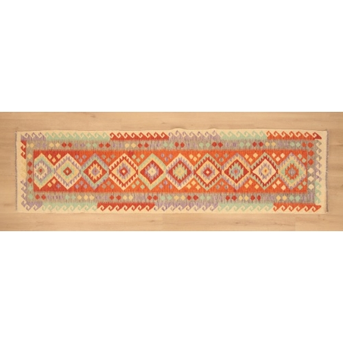 344 - AN ANATOLIAN KILIM RUNNER

woven in green, tan, lavender and other colours with endless lozenge pole... 