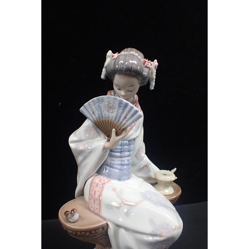 301 - A LLADRO PORCELAIN FIGURE OF A SEATED JAPANESE LADY holding a fan, 24cm high, with a box (flowers da... 