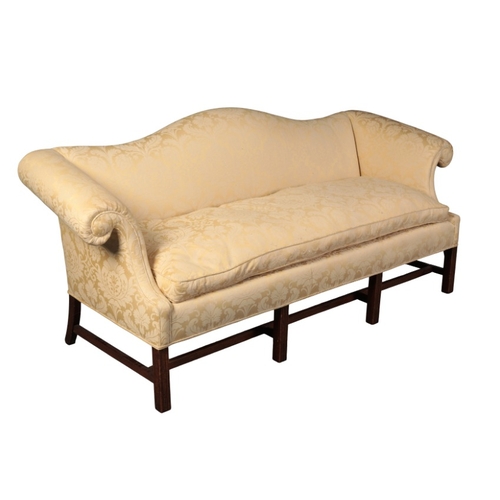 372 - A GEORGE III STYLE MAHOGANY CAMEL BACK SOFA

with golden damask covers, the scrolled arms over a squ... 