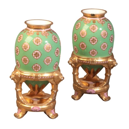 57 - A PAIR OF MINTON BONE CHINA VASES

19th century, modelled as ovoid urns supported by gilded stands, ... 