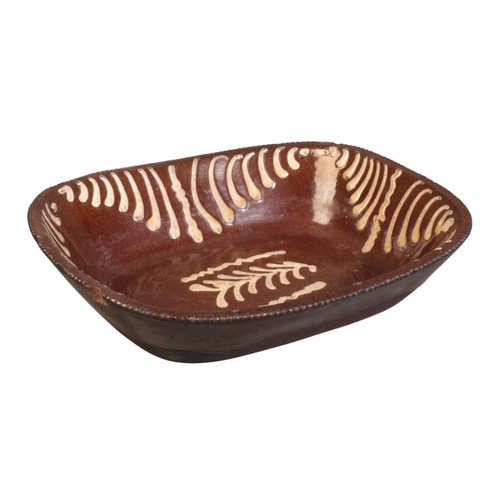 64 - AN ENGLISH TERRACOTTA SLIPWARE DISH

late 19th century, possibly Newcastle, 7.5cm high x 31cm wide

... 