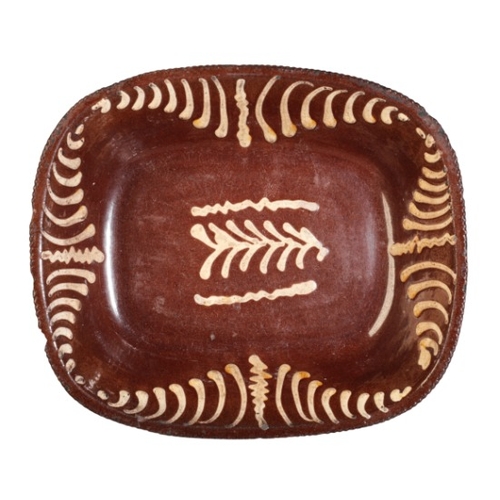 64 - AN ENGLISH TERRACOTTA SLIPWARE DISH

late 19th century, possibly Newcastle, 7.5cm high x 31cm wide

... 