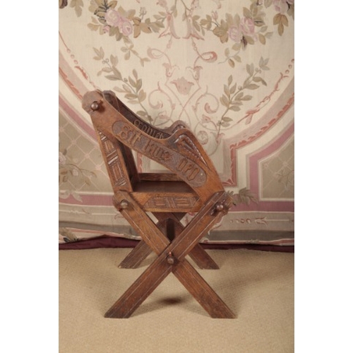 130 - AN OAK 'GLASTONBURY' ARMCHAIR

early 20th century, with carved decoration and lettering, 86cm high x... 