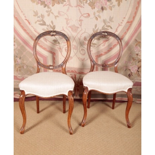 157 - A PAIR OF VICTORIAN WALNUT BALLOON-BACK SIDE CHAIRS

with carved and pierced cresting rail over cove... 