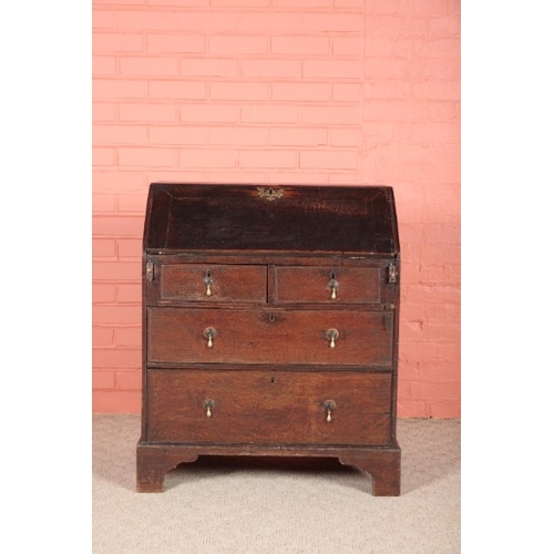 185 - A GEORGE II OAK BUREAU

the two short and two long drawers with pear-drop brass handles on bracket f... 