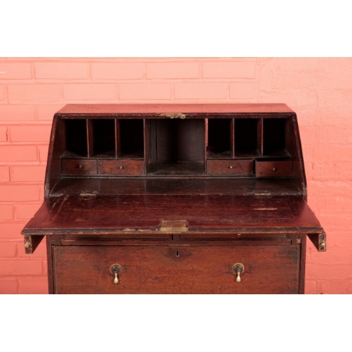 185 - A GEORGE II OAK BUREAU

the two short and two long drawers with pear-drop brass handles on bracket f... 