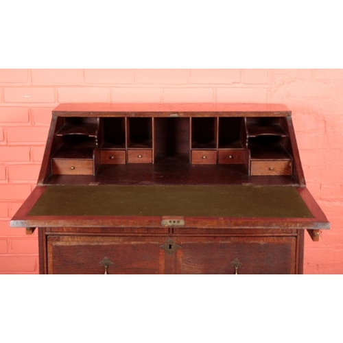 196 - AN OAK BUREAU

early 18th century, the fall front opening to a fitted interior with green baize-line... 