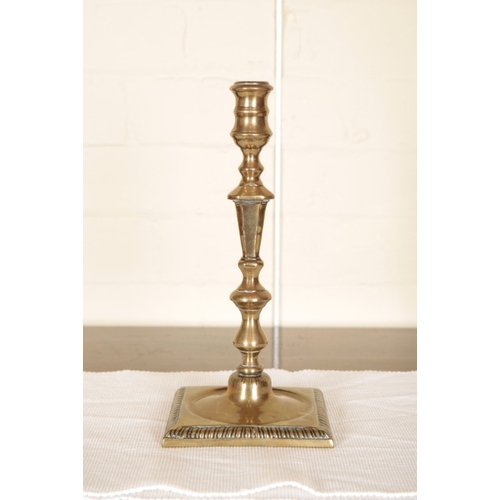 243 - A PAIR OF BRASS CANDLESTICKS

circa 1900, with turned sconce on square plinth bases, 26cm high (2)