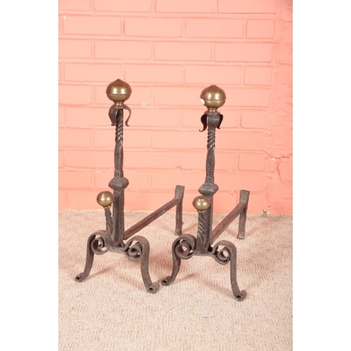 265 - A PAIR OF ARTS AND CRAFTS STYLE WROUGHT IRON FIRE DOGS

late 19th century, with brass ball finials a... 