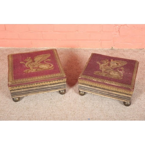 267 - A NEAR PAIR OF REGENCY EBONISED AND PARCEL GILT FOOTSTOOLS

with gryphon needlework covers, 18cm hig... 