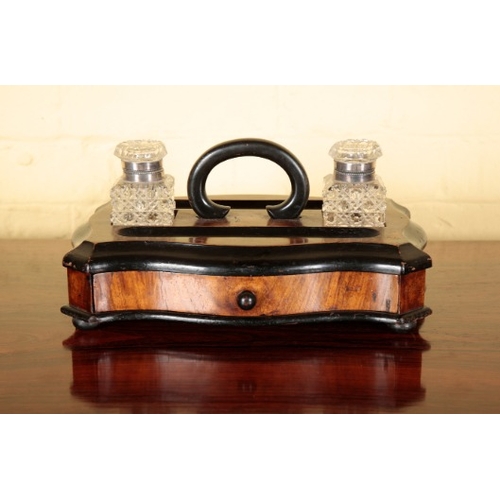 301 - A VICTORIAN WALNUT AND EBONISED SERPENTINE STANDISH

with two cut glass inkwells above a single frie... 