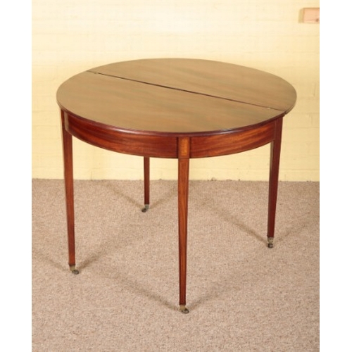 422 - A GEORGE III MAHOGANY DEMI-LUNE TEA TABLE

on square tapered legs terminating in brass toes and cast... 