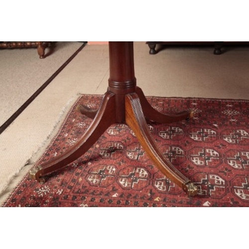 51 - A REGENCY STYLE MAHOGANY DINING TABLE

the top with reeded edge on turned pillars and quadruped base... 