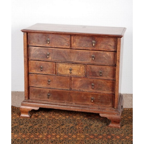 520 - A WALNUT AND PARQUETRY CHEST OF DRAWERS

18th century, the herringbone crossbanded top over an arran... 