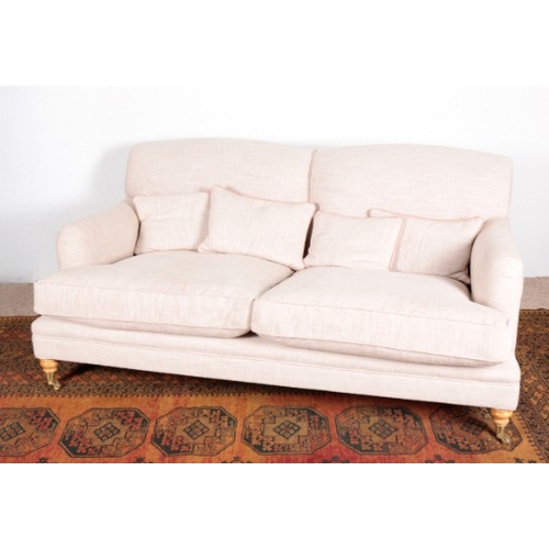 538 - A HOWARD TYPE TWO-SEATER SOFA

20th century, on turned front legs with castors and square rear legs,... 