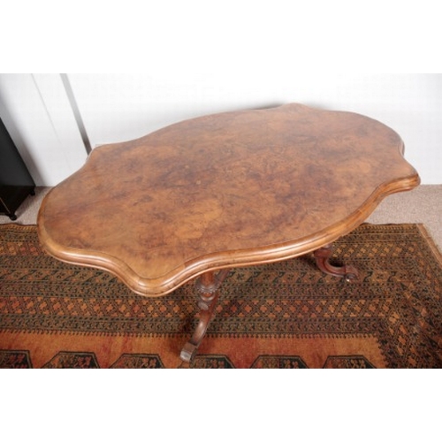 568 - A VICTORIAN WALNUT AND BURR WALNUT CENTRE TABLE

the shaped quarter veneered top on turned and flute... 