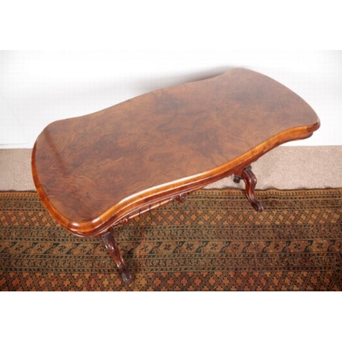 575 - A VICTORIAN WALNUT OCCASIONAL TABLE

the shaped quarter veneered top on turned and carved supports j... 