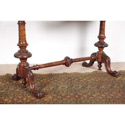 575 - A VICTORIAN WALNUT OCCASIONAL TABLE

the shaped quarter veneered top on turned and carved supports j... 