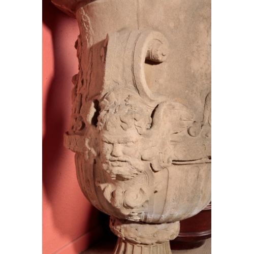 58 - A LARGE COMPOSITE STONE GARDEN URN

circa 1880, the body decorated in relief with putti and goats, w... 