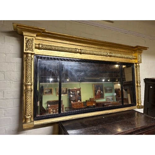 732 - A REGENCY GILTWOOD OVERMANTEL MIRROR

with floral decorated columns and ebonised beading, 81cm x 145... 