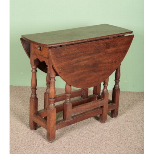 799 - AN OAK GATELEG TABLE

late 17th century, the oval top above a single frieze drawer, on turned legs j... 