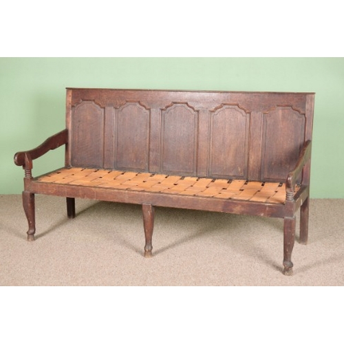 809 - AN OAK SETTLE

late 18th century, carved with five decorative recessed panels, the downswept arms ab... 