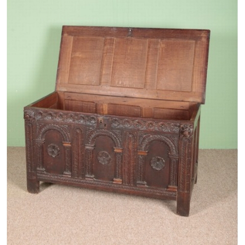 817 - A CARVED OAK CHEST

18th century, with a three panel top, the front with carved decoration of lion m... 