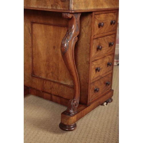 82 - A VICTORIAN WALNUT DAVENPORT

the hinged top with a pierced three-quarter gallery and opening to a s... 