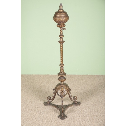 833 - A VICTORIAN GILT METAL STANDARD LAMP

ornately cast with profuse foliate decoration, on a tripod bas... 