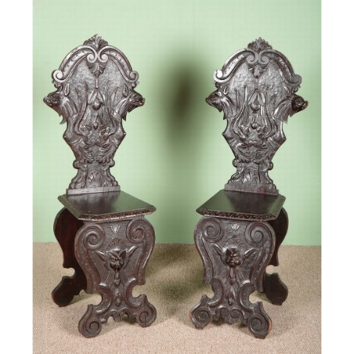 844 - A PAIR OF 'SGABELLO' HALL CHAIRS

19th century, each back with a heavily carved wolf's head, 123cm h... 