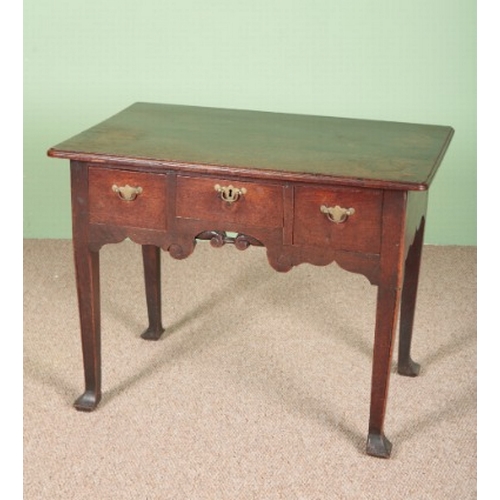 848 - A PROVINCIAL OAK LOW BOY

the top with a moulded edge over three drawers and a shaped apron, on tape... 