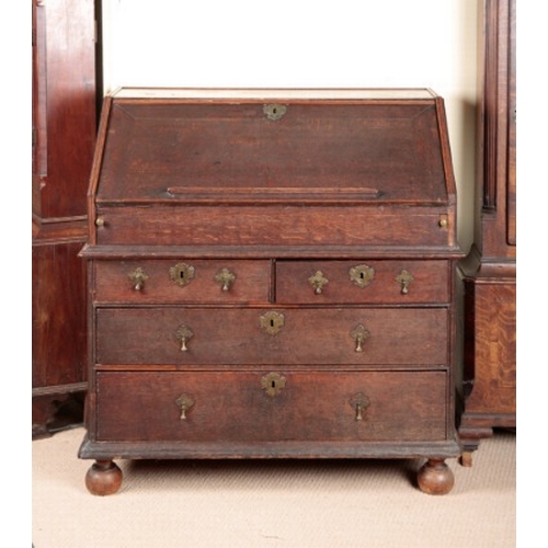 856 - AN OAK BUREAU

early 18th century, the fall front opening to an interior fitted with small drawers a... 