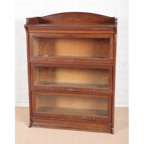 862 - A 1930S LEBUS OAK THREE TIER SECTIONAL BOOKCASE

with arched gallery top and dentil frieze, the thre... 