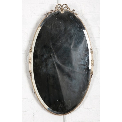 886 - A LATE VICTORIAN GILT GESSO OVAL WALL MIRROR

with scrolled leaf cresting, conforming apron, ovolo b... 